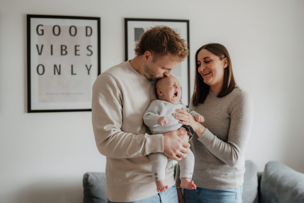 Reportage Fotoshooting mit einem Baby. Mama und Papa Kuscheln